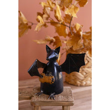 Recycled Metal Bat Holding A Pumpkin