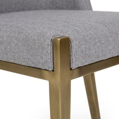 Modern grey and brass dining chair with padded seat and sleek design